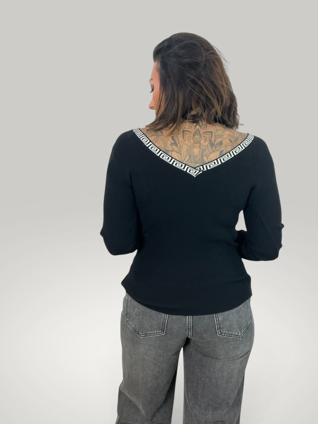Blusa preta Isabelle Hannover com decote em V e detalhe de padrão grego nas costas, corte casual e mangas compridas.