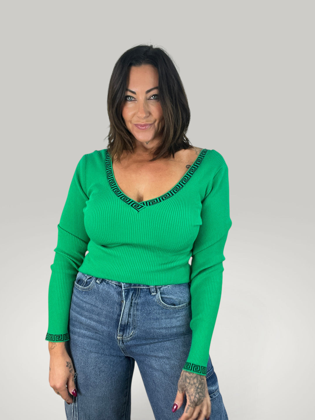 Blusa verde Isabelle Hannover com decote em V, detalhe de padrão grego e mangas compridas justas em tecido elástico
