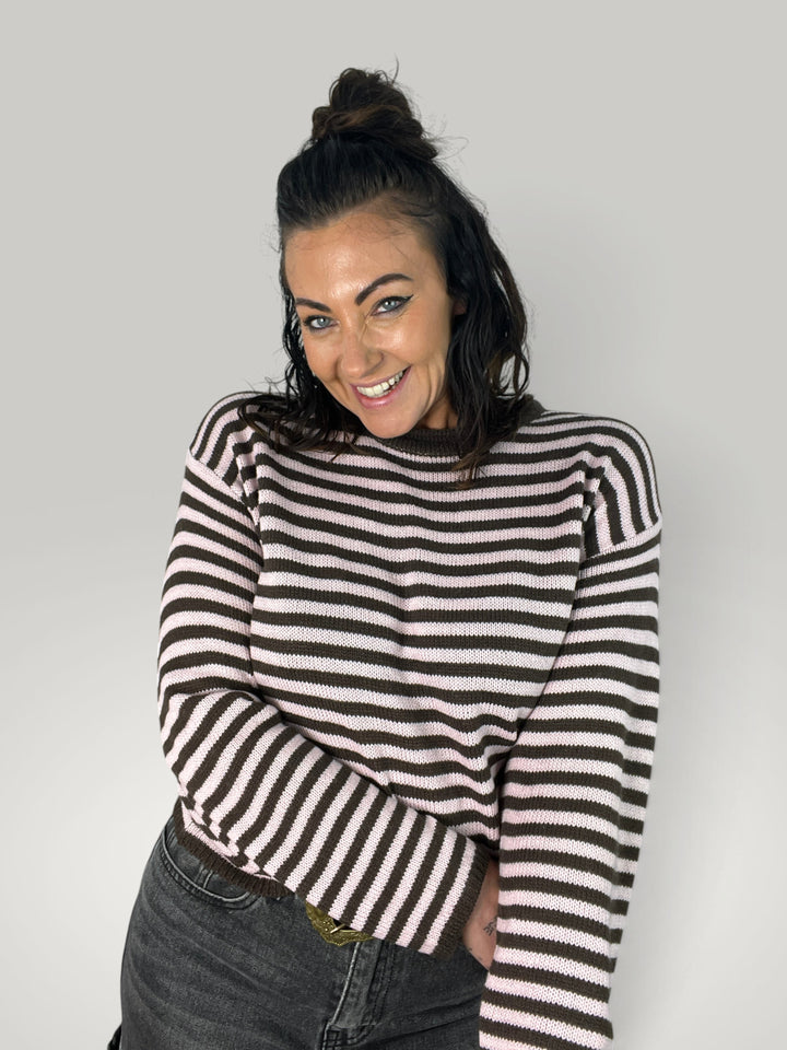 Modelo sorridente veste camisola curta Isabelle Hannover às riscas castanhas e creme com gola redonda e corte largo