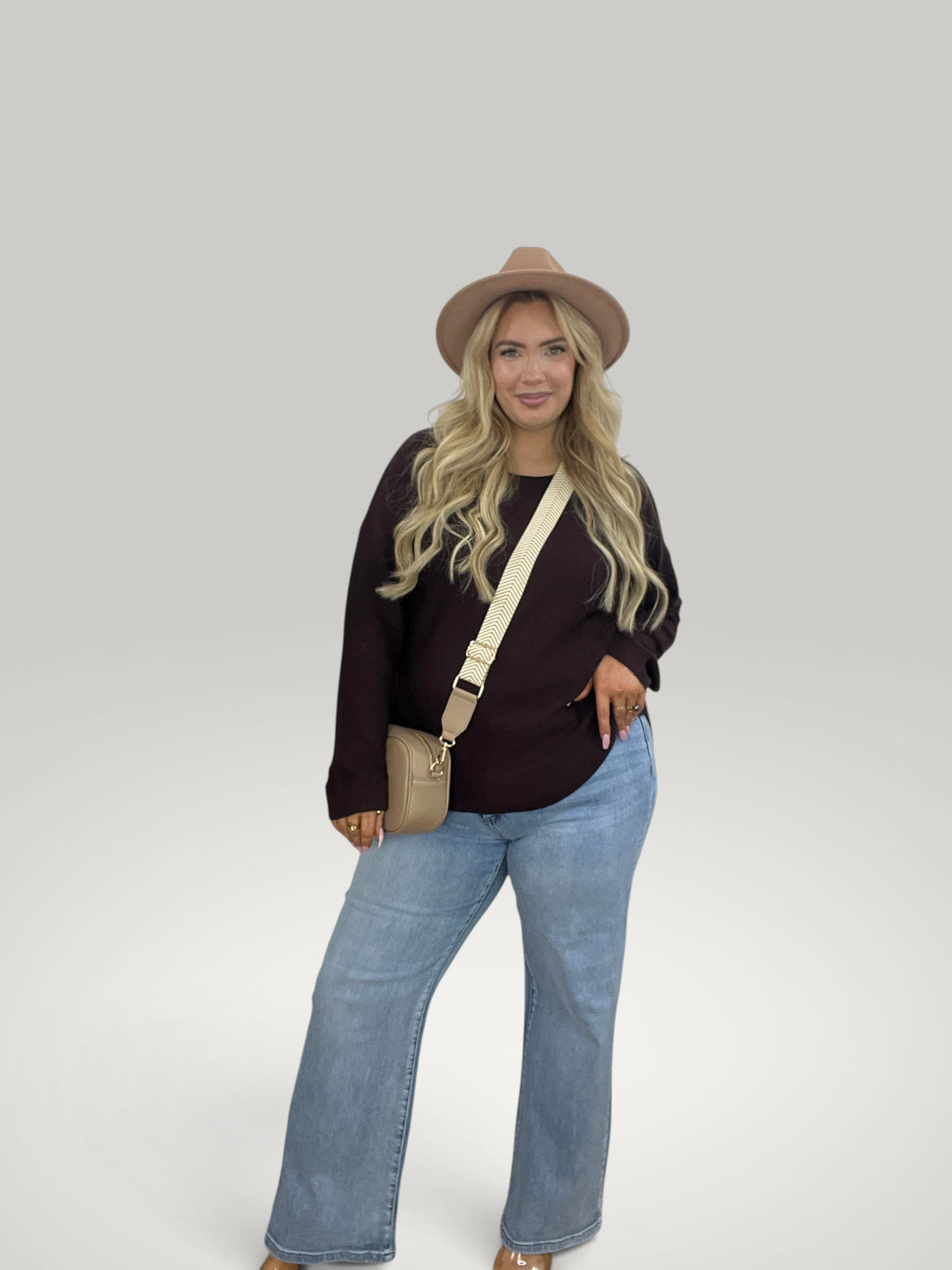 Isabelle Hannover camisola de malha roxa com decote barco, mangas compridas e corte casual, usada com jeans e chapéu