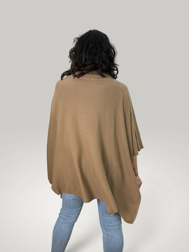 Vista traseira do poncho bege Isabelle Hannover com gola alta canelada, corte oversized e mangas curtas em malha macia.