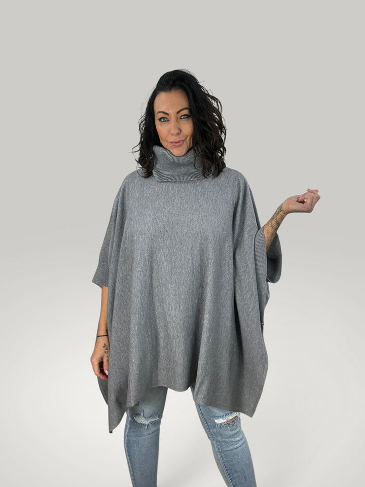 Modelo veste poncho cinzento Isabelle Hannover em malha macia com gola alta e corte oversized