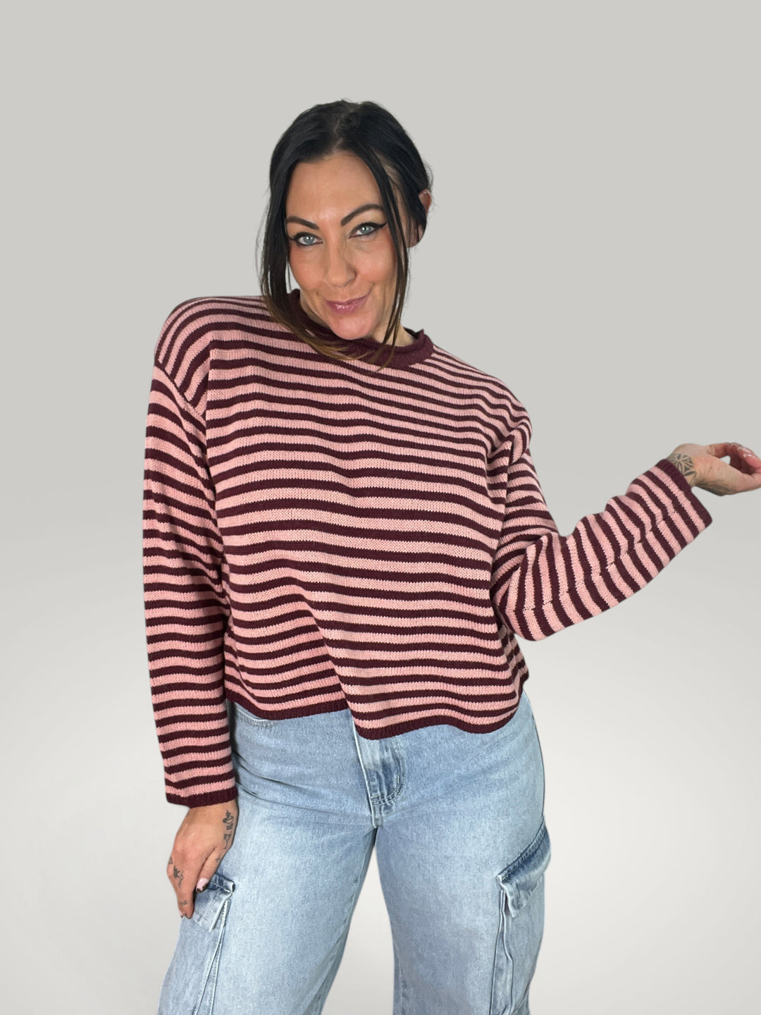 Pullover curto Isabelle Hannover às riscas rosa e bordeaux com corte quadrado, gola redonda e mangas compridas.