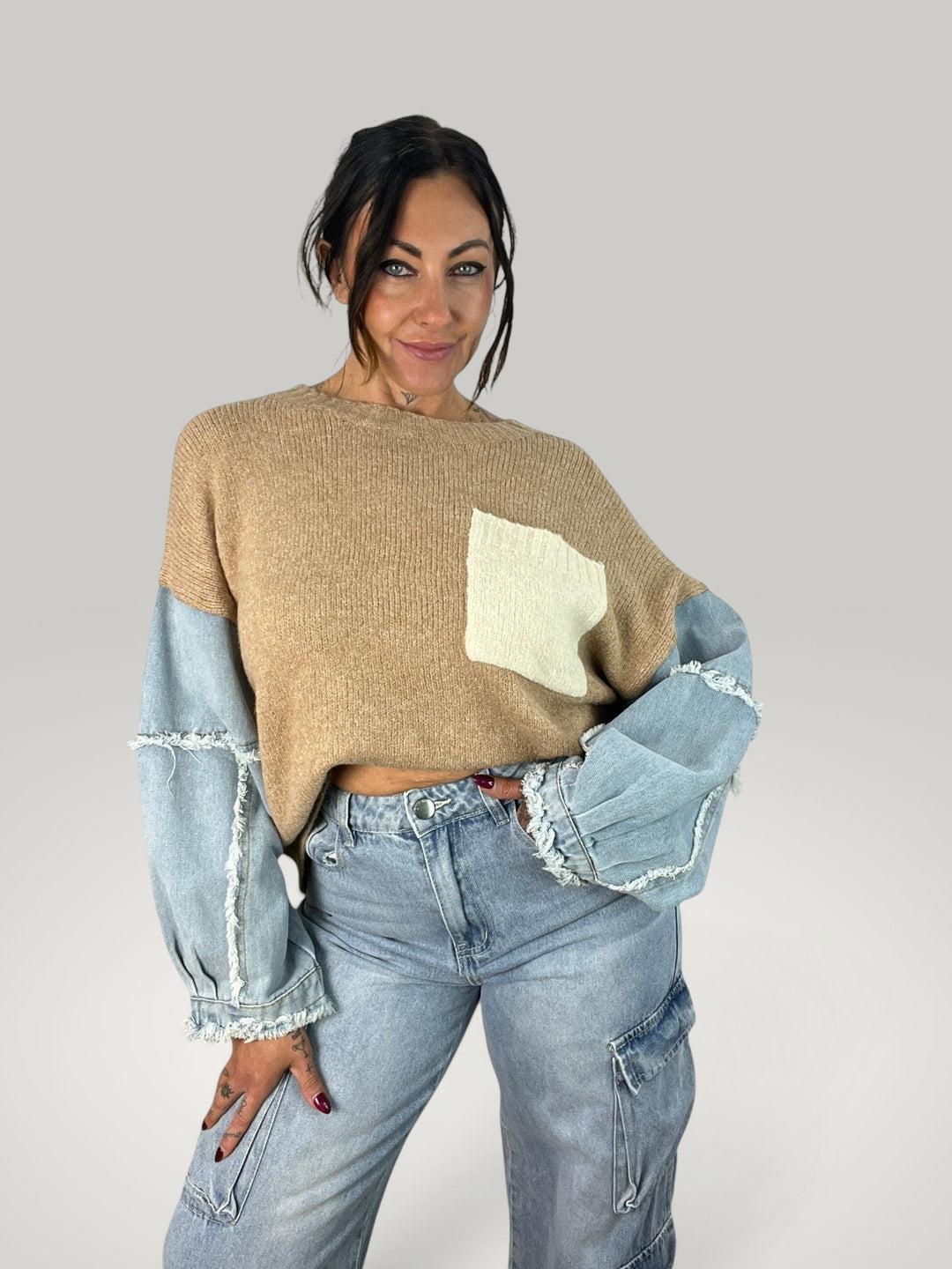 Isabelle Hannover pulôver bege com mangas de ganga contrastantes e bolso frontal, estilo casual com gola redonda.