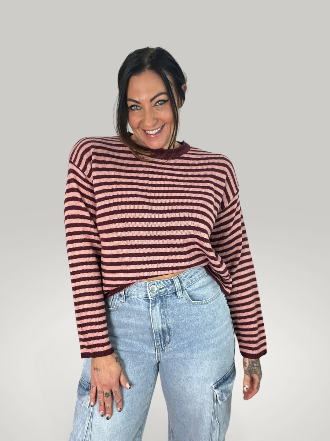 Mulher sorridente a usar o pulôver curto às riscas Marlene da Isabelle Hannover com decote redondo e ombros caídos