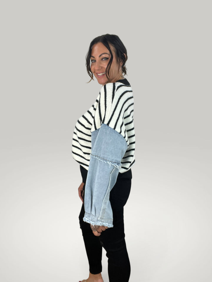Modelo veste pulôver Isabelle Hannover listrado com mangas de ganga contrastantes e gola redonda em fundo neutro