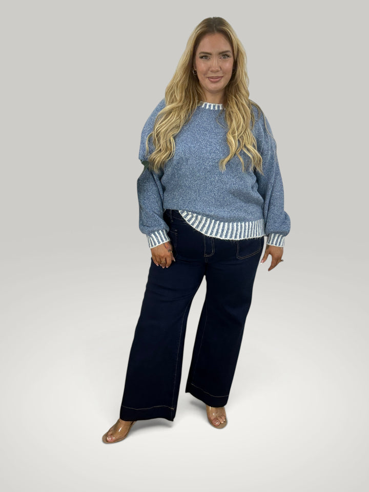 Modelo veste pulôver de malha azul Isabelle Hannover com gola redonda e detalhes de listras contrastantes