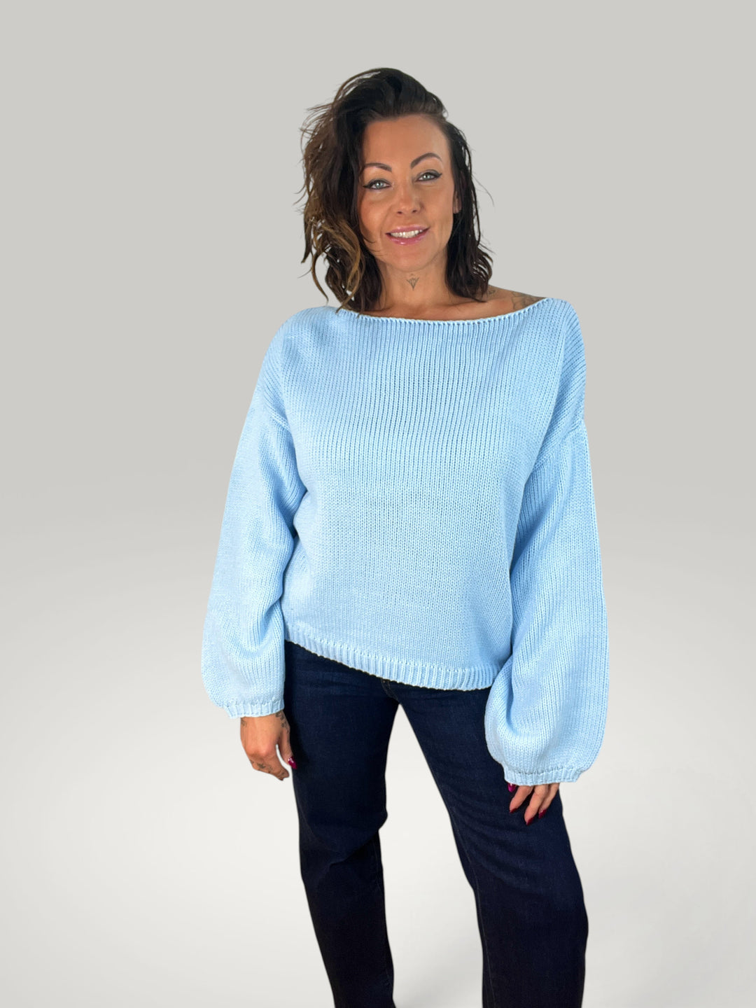 Modelo veste pulôver de malha azul claro Isabelle Hannover com corte largo, gola redonda e mangas balão