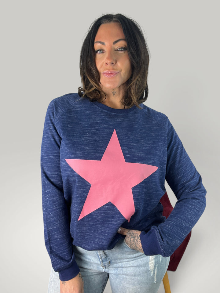 Mulher vestindo sweatshirt Isabelle Hannover azul com estampa de estrela rosa, gola redonda e corte descontraído.