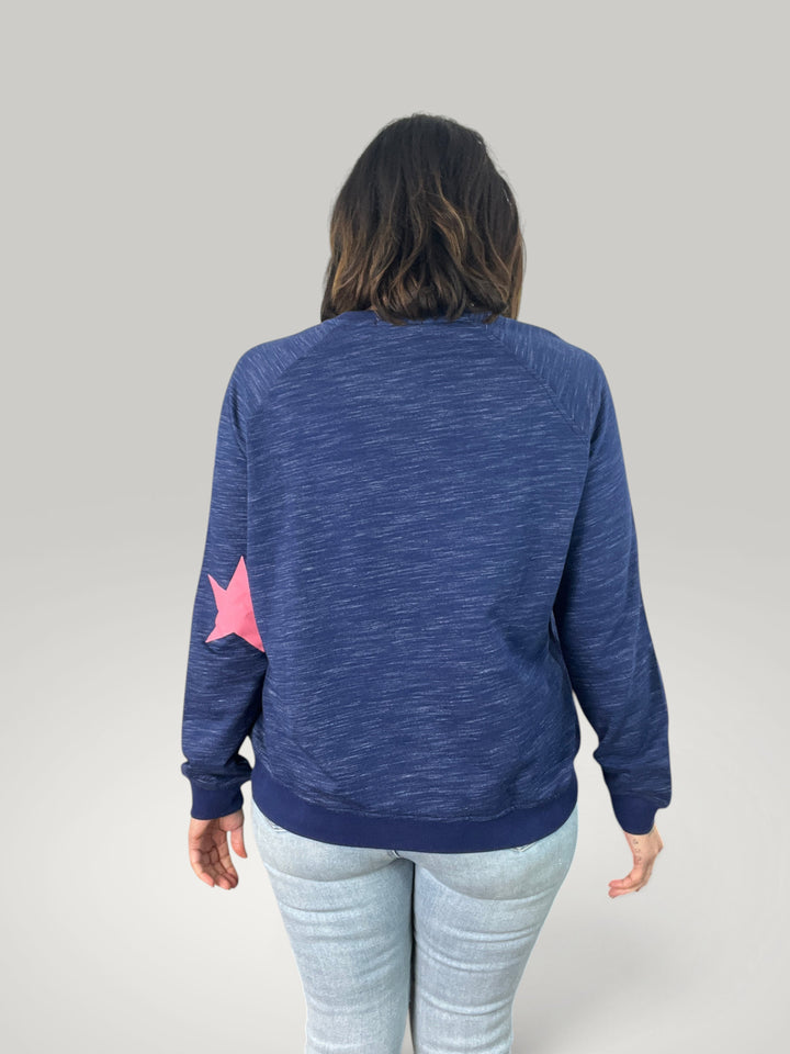Sweatshirt Isabelle Hannover azul com estampado de estrela rosa nas costas, corte largo e mangas compridas