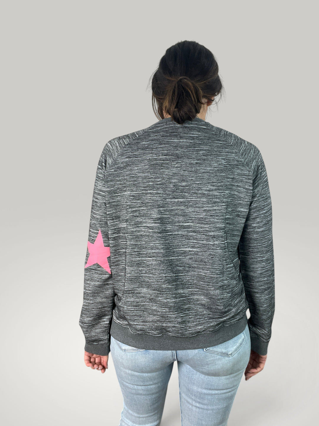 Sweatshirt Isabelle Hannover cinzento mesclado com estampado de estrela rosa na manga, corte largo e gola redonda.