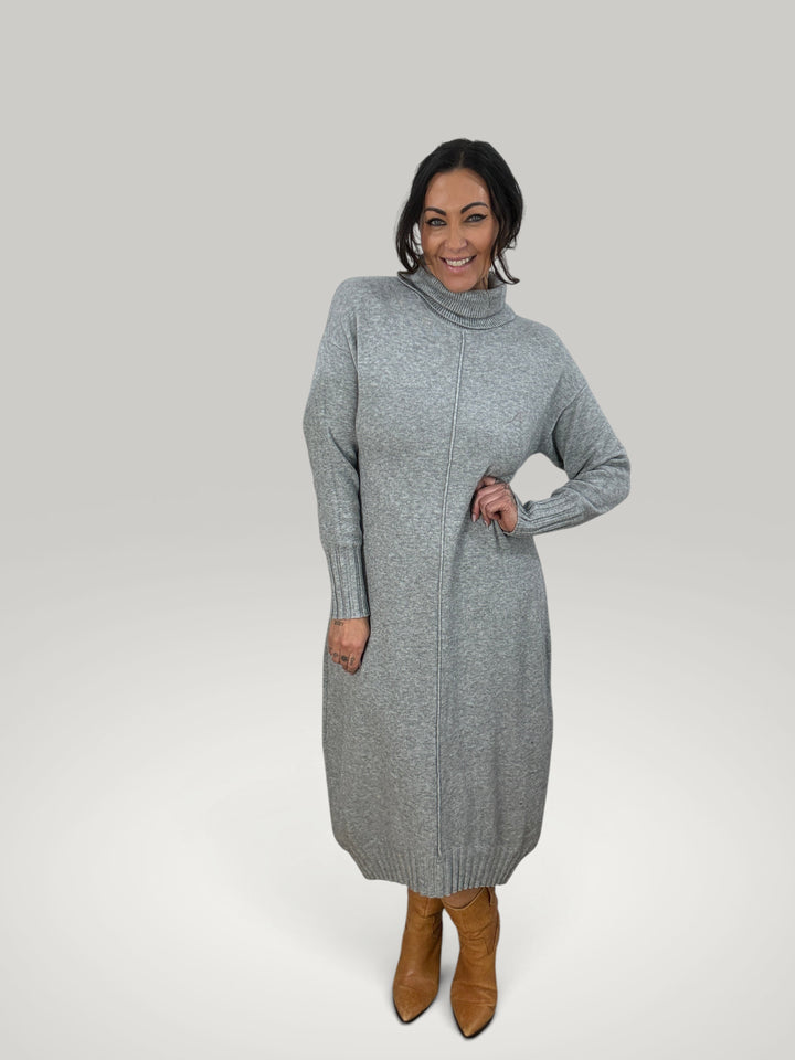 Modelo veste vestido de malha cinzento Isabelle Hannover com gola alta e mangas compridas em fundo neutro