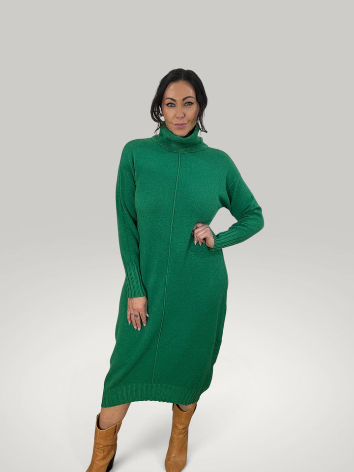 Modelo veste vestido de malha verde Isabelle Hannover com gola alta, mangas compridas e corte descontraído.